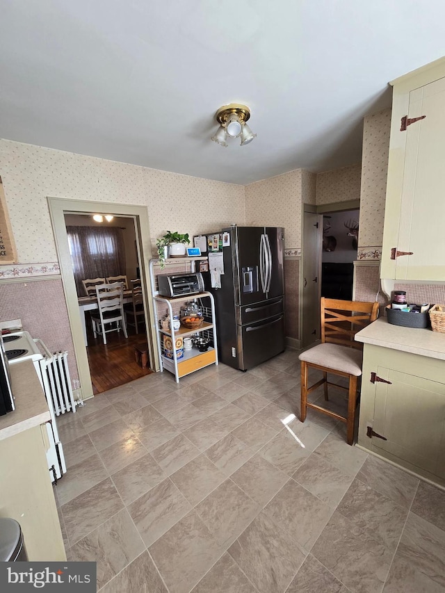 3880 Laurel Grove Rd, Federalsburg, MD 21632 - kitchen with wallpapered walls, refrigerator with ice dispenser, light countertops, and radiator heating unit