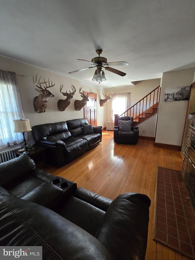 3880 Laurel Grove Rd, Federalsburg, MD 21632 - living room with stairway, ceiling fan, radiator heating unit, wood finished floors, and baseboards