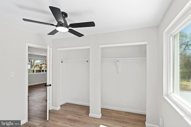 5004 Barnaby Ln, Oxon Hill, MD 20745 - unfurnished bedroom featuring baseboards, multiple windows, multiple closets, and wood finished floors