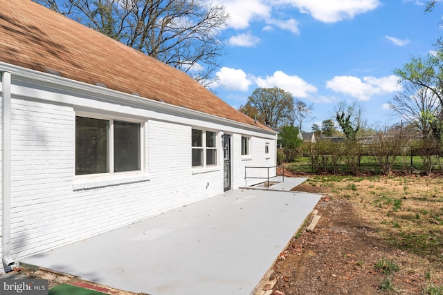 5004 Barnaby Ln, Oxon Hill, MD 20745 - exterior space with a patio area, a shingled roof, and brick siding