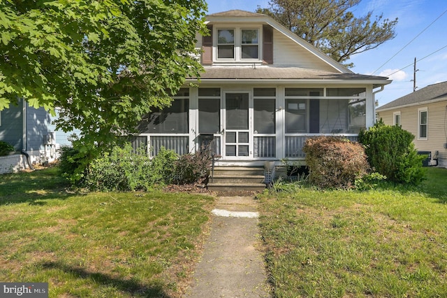 135 Pine St, Dover, DE 19901 - view of front of property featuring a sunroom, a front lawn, and a shingled roof