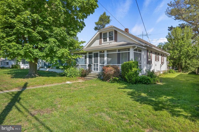 135 Pine St, Dover, DE 19901 - bungalow-style home with a chimney, a sunroom, and a front lawn