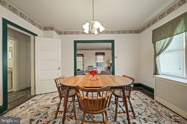 135 Pine St, Dover, DE 19901 - dining area with radiator, a chandelier, baseboards, and wood finished floors