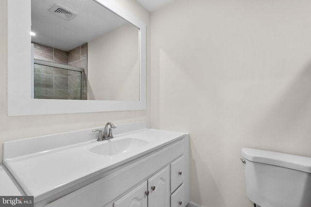 full bathroom featuring a stall shower, vanity, and toilet