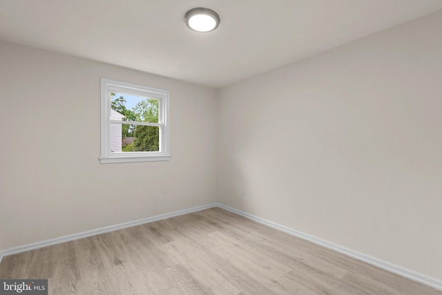 spare room with light wood-style floors and baseboards