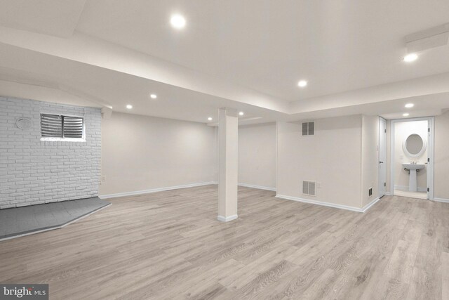 finished basement with light wood-type flooring, baseboards, and recessed lighting