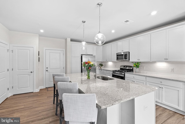 3927 Fair Ridge Dr Unit 305, Fairfax, VA 22033 - kitchen featuring appliances with stainless steel finishes, a sink, light wood-style floors, white cabinets, and recessed lighting