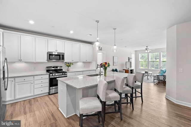 3927 Fair Ridge Dr Unit 305, Fairfax, VA 22033 - kitchen featuring appliances with stainless steel finishes, a sink, light wood-style flooring, white cabinetry, and recessed lighting