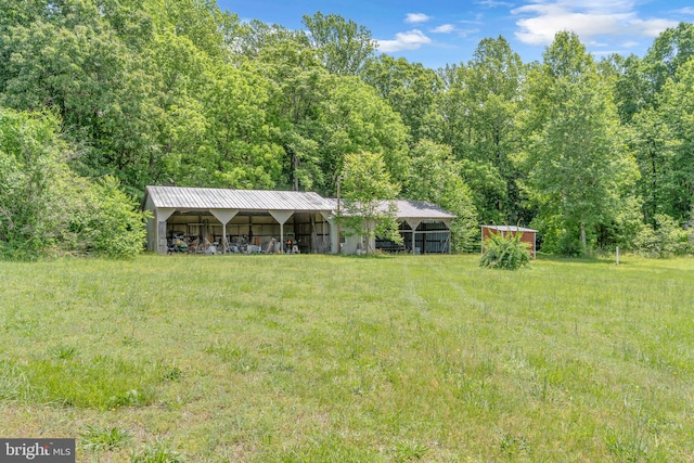 4152 Windy Hills Ln, King George, VA 22485 - view of yard featuring a pole building, an outdoor structure, a wooded view, and a detached carport
