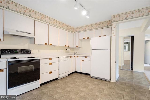 kitchen with a sink, white appliances, track lighting, under cabinet range hood, and light countertops