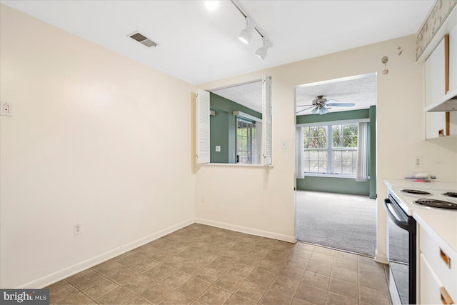 kitchen with rail lighting, carpet flooring, a ceiling fan, baseboards, and range with electric cooktop