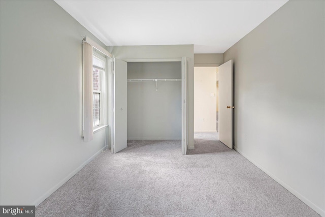 unfurnished bedroom featuring carpet flooring, a closet, and baseboards