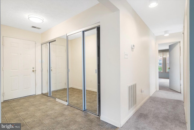hallway featuring baseboards and visible vents