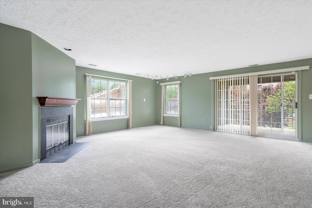 unfurnished living room with a textured ceiling, carpet, and a fireplace with flush hearth