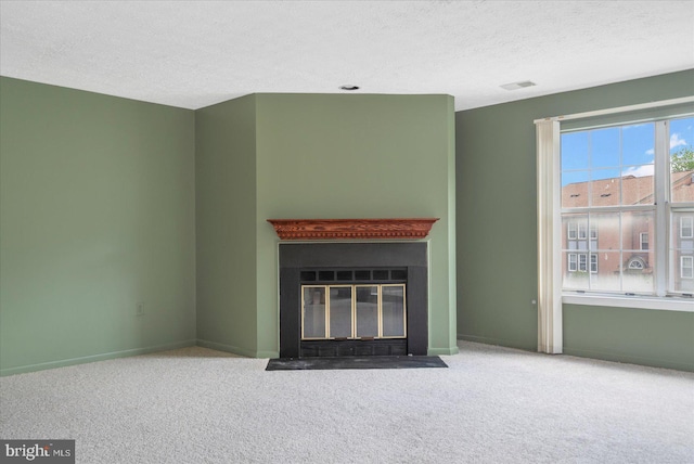 unfurnished living room with a textured ceiling, carpet flooring, baseboards, and a fireplace with flush hearth