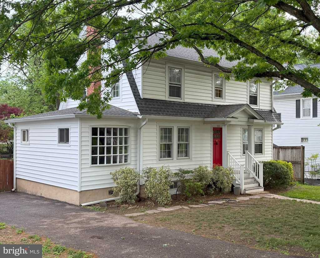 view of front of property featuring a shingled roof and fence