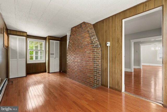 331 E Maple Rd, Linthicum Heights, MD 21090 - unfurnished room featuring hardwood / wood-style flooring, wooden walls, baseboards, and a baseboard heating unit