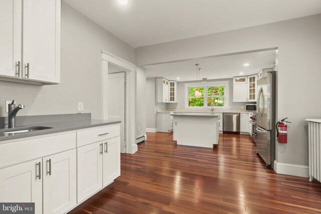 331 E Maple Rd, Linthicum Heights, MD 21090 - kitchen featuring stainless steel appliances, a sink, baseboard heating, dark wood finished floors, and white cabinetry