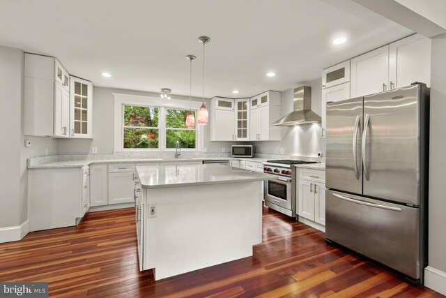331 E Maple Rd, Linthicum Heights, MD 21090 - kitchen with appliances with stainless steel finishes, wall chimney exhaust hood, light countertops, dark wood-type flooring, and white cabinetry