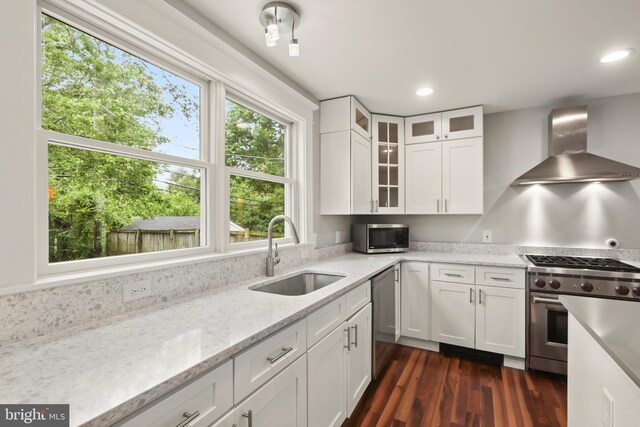 331 E Maple Rd, Linthicum Heights, MD 21090 - kitchen featuring a sink, wall chimney exhaust hood, appliances with stainless steel finishes, white cabinetry, and recessed lighting