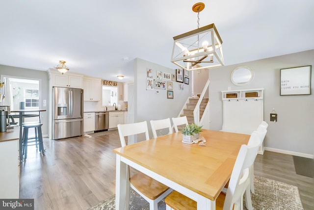 40 Robarts Dr, Phoenixville, PA 19460 - dining room featuring light wood finished floors, an inviting chandelier, stairway, and baseboards