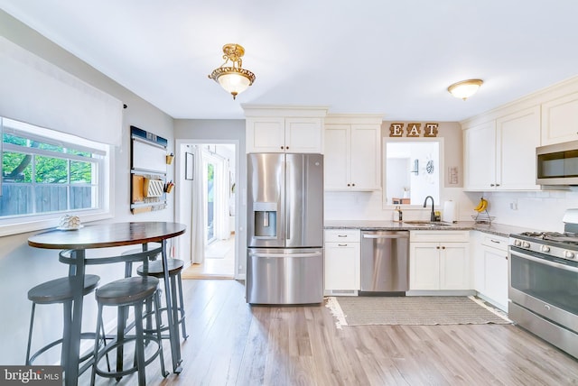 40 Robarts Dr, Phoenixville, PA 19460 - kitchen with light stone countertops, a sink, backsplash, stainless steel appliances, and light wood-type flooring