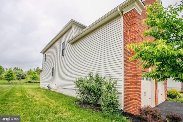 4902 Bridle Ridge Rd, Upper Marlboro, MD 20772 - view of side of home featuring a lawn, brick siding, and a garage