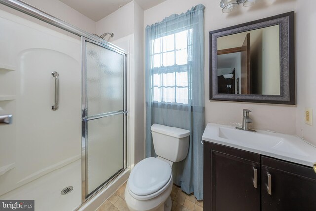 bathroom with a shower stall, toilet, and vanity