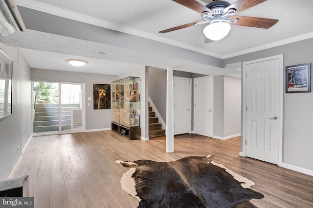 interior space with baseboards, a textured ceiling, and wood finished floors