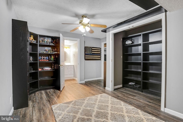 unfurnished bedroom with baseboards, a textured ceiling, and wood finished floors