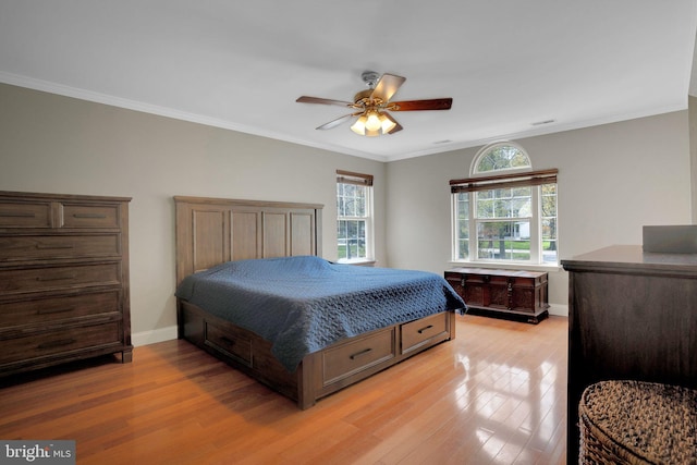 bedroom featuring ceiling fan, light wood-type flooring, baseboards, and ornamental molding