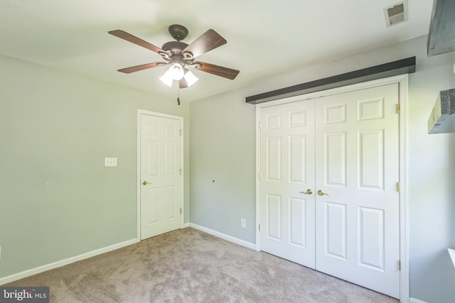 unfurnished bedroom with a closet, baseboards, carpet flooring, ceiling fan, and visible vents