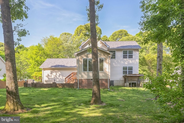 rear view of property featuring a lawn