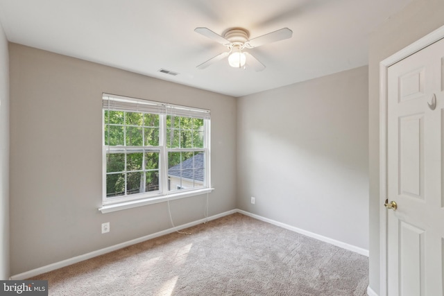 spare room with baseboards, ceiling fan, visible vents, and carpet