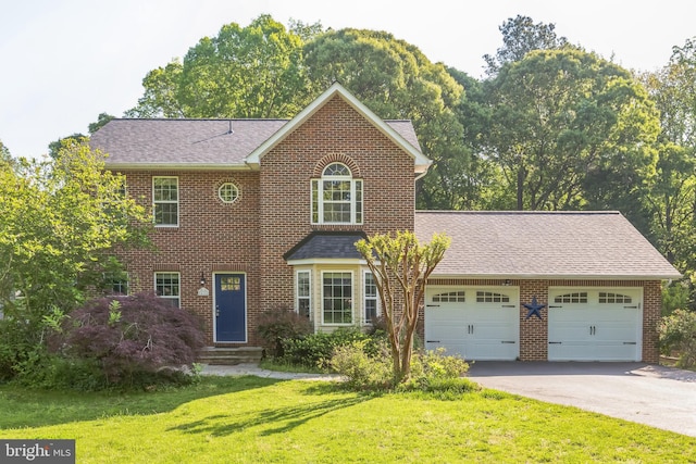 view of front of property featuring a front lawn, brick siding, a garage, and aphalt driveway