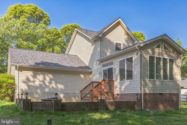 rear view of house featuring central AC unit, a yard, and crawl space