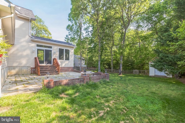 view of yard with fence, a shed, an outdoor structure, a patio area, and entry steps