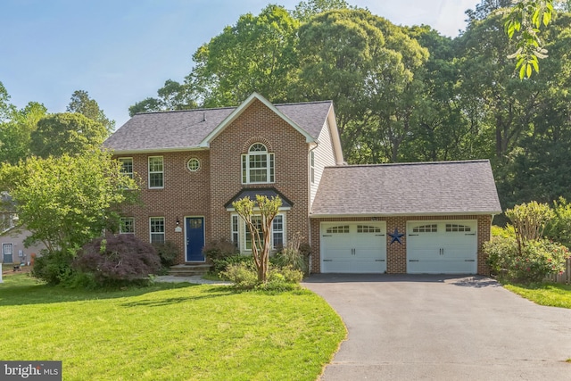 colonial house featuring an attached garage, brick siding, a front lawn, and aphalt driveway
