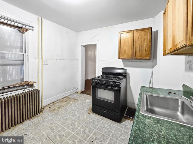 1837 W Juniata St, Philadelphia, PA 19140 - kitchen with gas stove, radiator, a sink, light tile patterned floors, and brown cabinetry