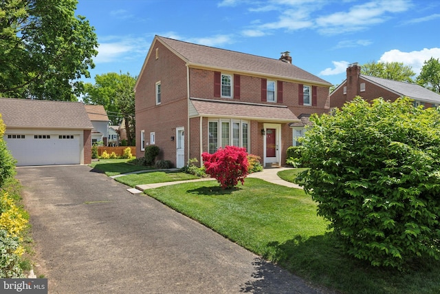 949 Laurance Ave, Elkins Park, PA 19027 - view of front of property with brick siding, a detached garage, a front lawn, and a chimney