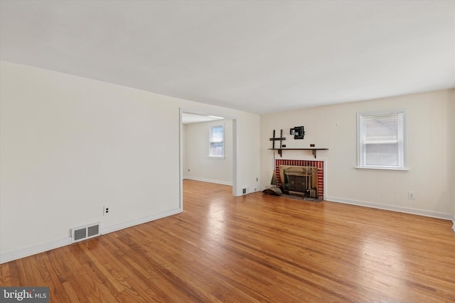 949 Laurance Ave, Elkins Park, PA 19027 - unfurnished living room featuring light wood-style flooring, a brick fireplace, and baseboards