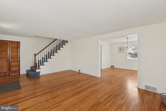 949 Laurance Ave, Elkins Park, PA 19027 - unfurnished living room featuring a chandelier, light wood-style floors, stairway, and baseboards