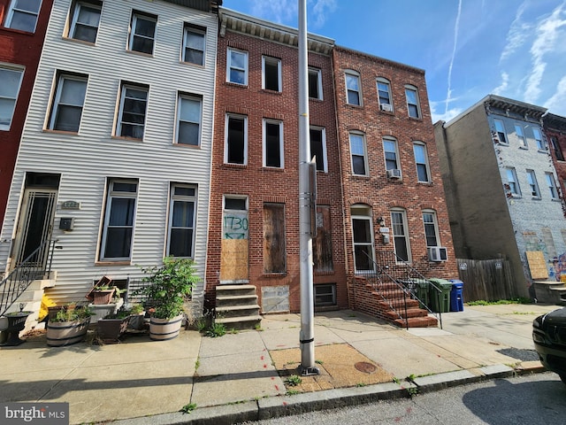 multi unit property featuring entry steps, cooling unit, and brick siding