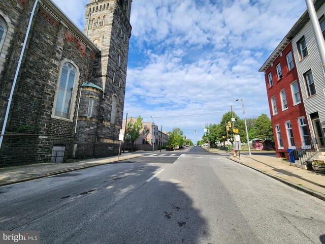 view of street featuring street lighting, curbs, and sidewalks