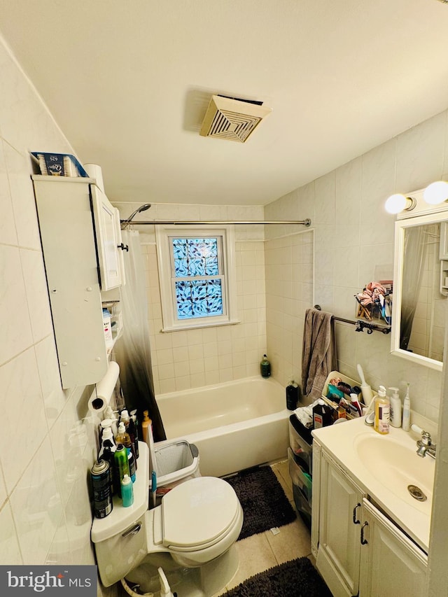 full bathroom with tile walls, toilet, shower / bath combo, vanity, and tile patterned flooring