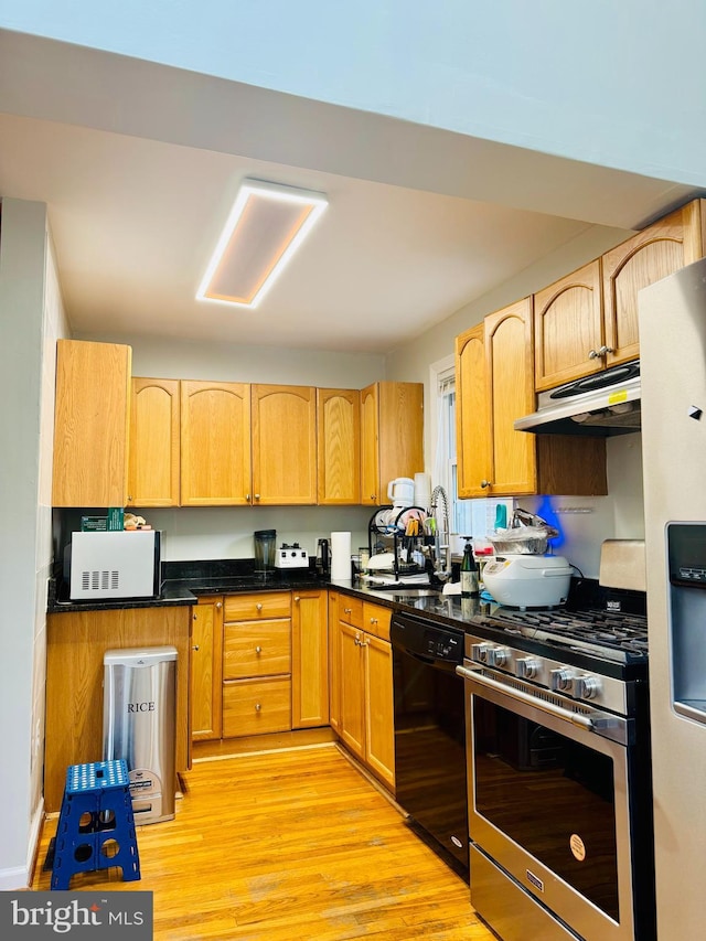 kitchen with stainless steel gas range, black dishwasher, white microwave, under cabinet range hood, and a sink