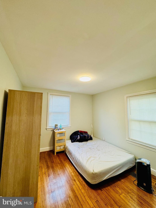 bedroom featuring wood-type flooring and baseboards