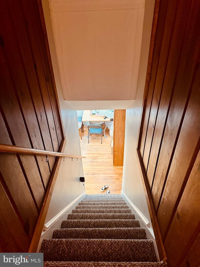 stairs featuring wood finished floors and baseboards