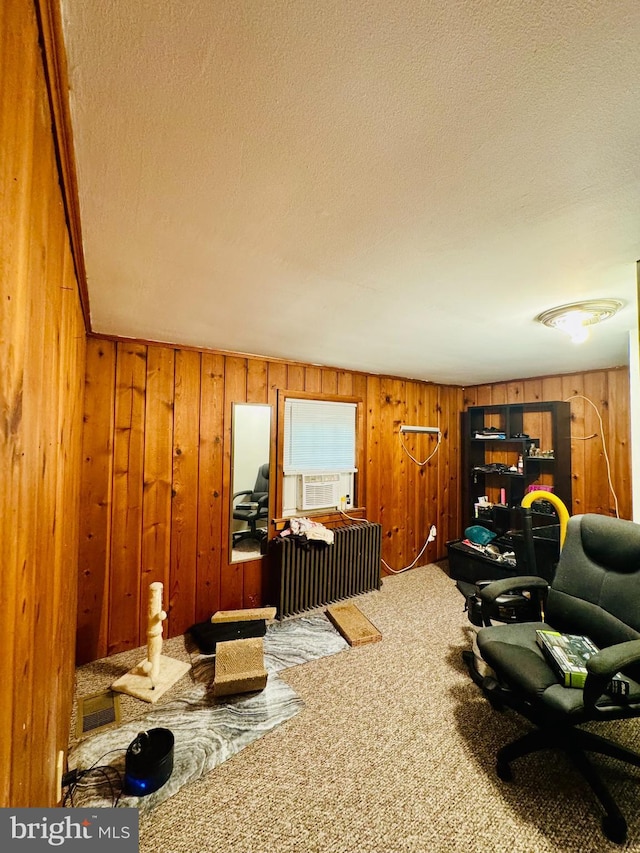 carpeted office space with wood walls, a textured ceiling, and cooling unit