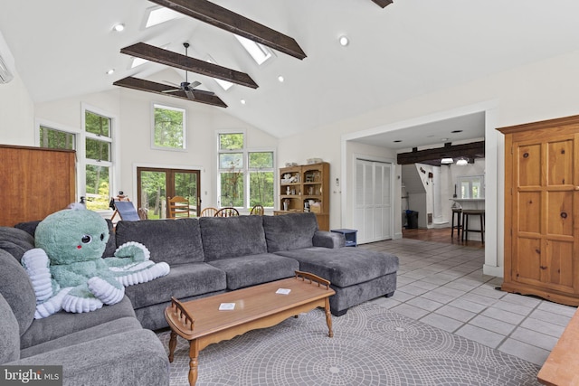 living room featuring high vaulted ceiling, beam ceiling, a skylight, a healthy amount of sunlight, and light tile patterned flooring